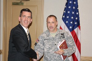 Col. Dominic Caraccilo, USA (r), deputy chief of staff, U.S. Army Forces Command, receives a chapter coin from Paul Reimers, chapter president, at the chapter's February meeting.